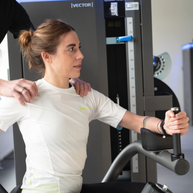 Gregor Mini kontrolliert und korrigiert die korrekte Ausführung einer Übung einer Patientin.