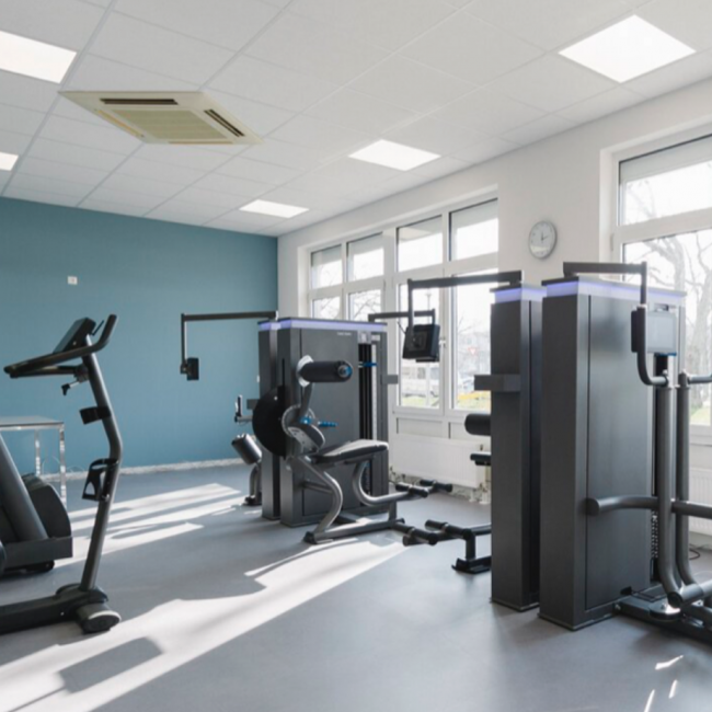 Lichtdurchflutete Räumlichkeiten des Kraftraums mit Geräten. Fensterfront