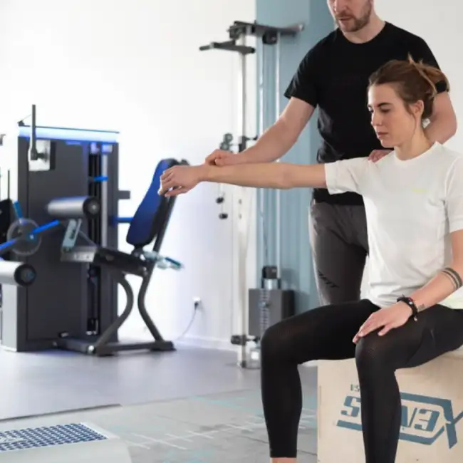 Gregor Mini kontrolliert und korrigiert die korrekte Ausführung einer Übung einer Patientin.