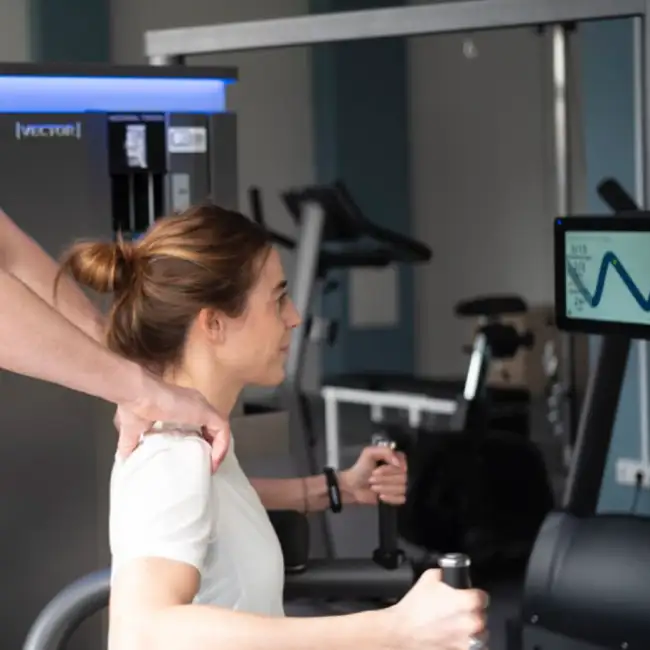 Gregor Mini kontrolliert und korrigiert die korrekte Ausführung einer Übung einer Patientin