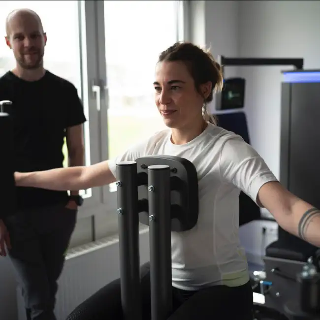 Gregor Mini kontrolliert und korrigiert die korrekte Ausführung einer Übung einer Patientin