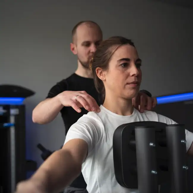 Gregor Mini kontrolliert und korrigiert die korrekte Ausführung einer Übung einer Patientin