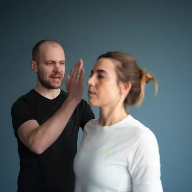 Gregor Mini kontrolliert und korrigiert die korrekte Ausführung einer Übung einer Patientin