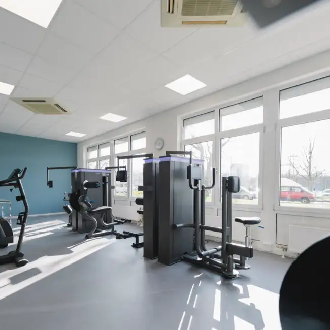 Lichtdurchflutete Räumlichkeiten des Kraftraums mit Geräten. Fensterfront